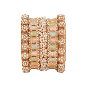 Set of decorative bangles held by a hand against a neutral background
