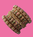 Set of decorative bangles held by a hand against a neutral background